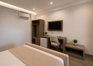 a bedroom with a bed and a desk and a television at Hotel Mare 2 in Ksamil
