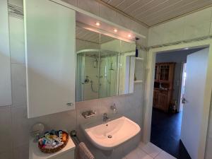 a white bathroom with a sink and a shower at "An der alten Mühle 1" Große Fewo 110 qm, sehr zentral gelegen, zwei Schlafzimmer, Südbalkon, Gartenterrasse & Wallbox in Bad Bentheim +69 photos