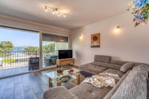 a living room with a couch and a tv at Apartments Doris in Malinska