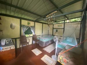 a room with a bed and a table and chairs at One Ocean Nature Conservation Centre in Kota Belud