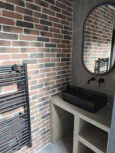 a bathroom with a sink and a brick wall at Escale à Clisson - l'Hippo Loft in Clisson