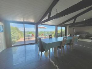 a dining room with a table and chairs with a view at Gîtes & Chambres d'hôtes Peyrecout in Laparrouquial
