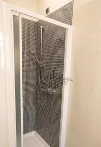 a shower in a bathroom with a tile wall at Bijou - Lake side apartments in Sandra
