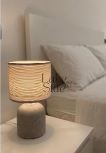 a lamp sitting on a table next to a bed at Bijou - Lake side apartments in Sandra