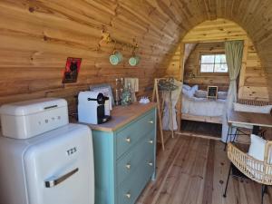 a kitchen in a log cabin with a bed at De Remise in Hengelo