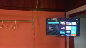 a flat screen tv hanging from a wall at Pousada Oliveira Ramos in Lumiar