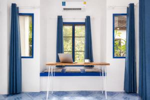 a table with a laptop on it in front of a window at Archie Village in Hinkong
