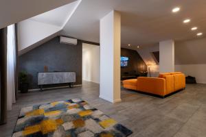 a living room with an orange couch and a tv at Hotel Novy Kastiel - Self check-in in Topoľčany