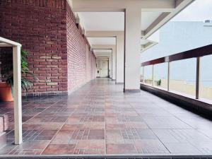 an empty hallway of a building with a brick wall at Vcp urban suites in Villa Carlos Paz