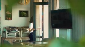 a woman standing in a room with a television at Season Suite Apart-Hotel in Batumi