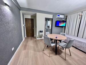 a room with a table and chairs and a bed at Vcp urban suites in Villa Carlos Paz