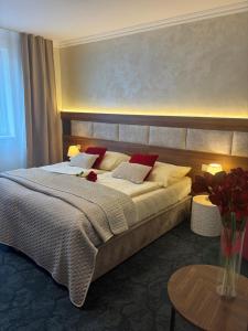 a bedroom with a large bed with red pillows at Hotel Garni Expo in Banská Bystrica