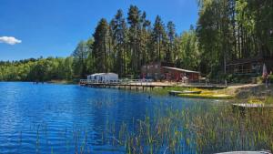 a view of a lake with a house and a dock at Mazury - Ruś domki wypoczynkowe nad samym jeziorem in Ruś