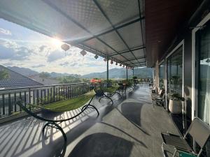 a porch with chairs and a hammock on a balcony at Phong Nha TuTu's House in Phong Nha +12 photos