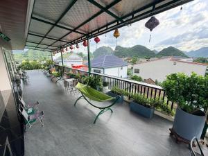 a patio with chairs and a balcony with mountains at Phong Nha TuTu's House in Phong Nha