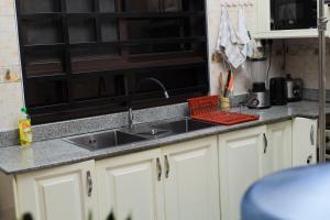 a kitchen counter with a sink and a microwave at Cozy Retreat in Kampala