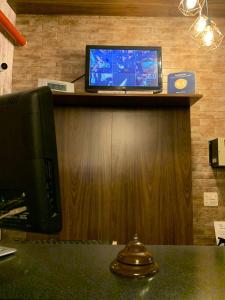 a tv sitting on top of a counter with a desk at Ibitur Hotel in Ibiúna +8 photos