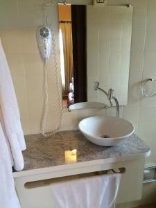 a bathroom with a sink and a phone on a counter at Ibitur Hotel in Ibiúna