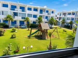 a playground in front of a large building at Perla Andalusia Bright 2BR Near Beach & Pool in Mansouria