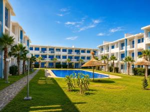 an exterior view of a resort with a swimming pool at Perla Andalusia Bright 2BR Near Beach & Pool in Mansouria