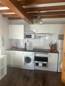 a white kitchen with a stove and a dishwasher at El Descanso Lastres in Colunga