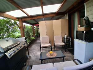 a screened in porch with a stove and chairs at La Varangue in La Possession