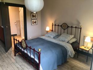 ein Schlafzimmer mit einem großen Bett, bezogen mit blauen Laken und Kissen. in der Unterkunft L'école perdue in Saint-Martin-dʼOllières