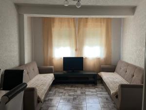 a living room with two couches and a television at Villa Gryka in Peje