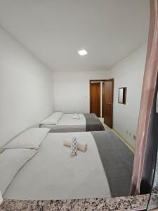 two beds in a small room with two beds at Pérola Rosa 04 in Ilhéus +33 photos
