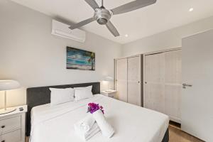 a bedroom with a white bed with flowers on it at Apartamento Sorbos in Dorp Sint Michiel