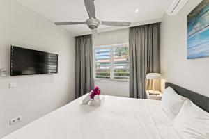 a bedroom with a large white bed with flowers on it at Apartamento Sorbos in Dorp Sint Michiel