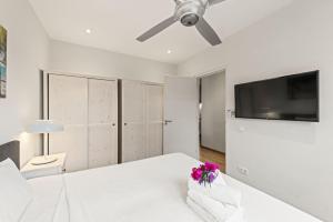 a bedroom with a white bed with a ceiling fan at Apartamento Sorbos in Dorp Sint Michiel