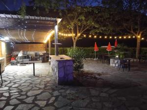 a patio at night with lights and tables and chairs at RELAIS du BECASSIER in Annot