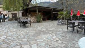 a patio with tables and chairs and red umbrellas at RELAIS du BECASSIER in Annot