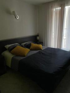 a bedroom with a large bed with yellow pillows at RELAIS du BECASSIER in Annot