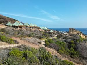 a house on a hill next to the ocean at La Ballenera Lodge in Guaquen