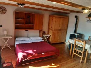 a bedroom with a bed with a red blanket at Nido Paradiso Nido, Balcone panoramico sulla Valle Soana in Ingria +24 photos