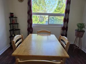 a wooden table and chairs in a room with a window at Centennial Suite in Niagara Falls +1 photo