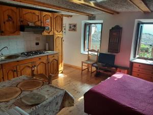 a kitchen with a table and a stove in a room at Nido Paradiso Nido, Balcone panoramico sulla Valle Soana in Ingria