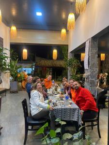 a group of people sitting at a table in a restaurant at Phong Nha TuTu's House in Phong Nha