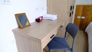 a desk with a mirror and a chair in a room at Didi House無人化自助入住 in Tainan