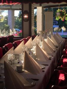 a long table with white napkins and wine glasses at Eckerö Hotell & Restaurang in Eckerö