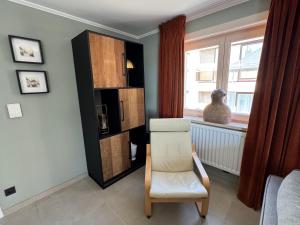 a living room with a chair and a window at Relax & Sea in Ostend