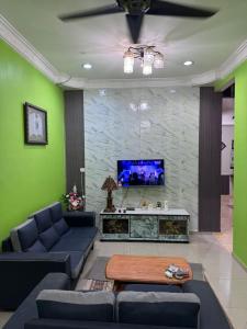 a living room with couches and a flat screen tv at Labis Homestay Afina in Labis