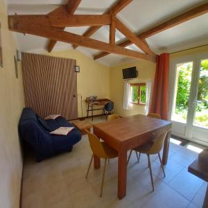 a living room with a wooden table and chairs at Domaine La Salamandre - Piscine & Forêt privée, Vue sur Vallée in Lauzerte