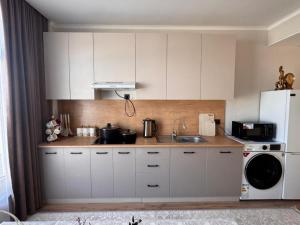 a kitchen with white cabinets and a white refrigerator at Karagay resort in Bosteri