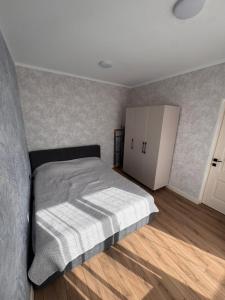 a bedroom with a bed and a white cabinet at Karagay resort in Bosteri