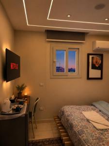 a bedroom with a bed and a desk and a window at Pyramids Green View in Cairo