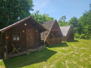 two small wooden buildings sitting in a yard at BORA- Popas Turistic casute de vacanta in Fîrdea