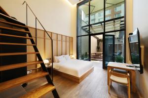 a bedroom with a bed and a staircase and a stair case at 브라운도트호텔동탄역점 구 js더클래식호텔 in Hwaseong